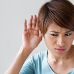 woman suffers from hearing loss impairment,